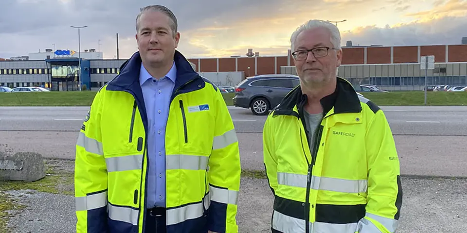 Två män i varseljackor